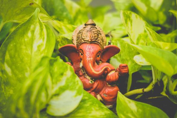 Ceramic sculpture of Lord Ganesha hiding among the shrubbery.